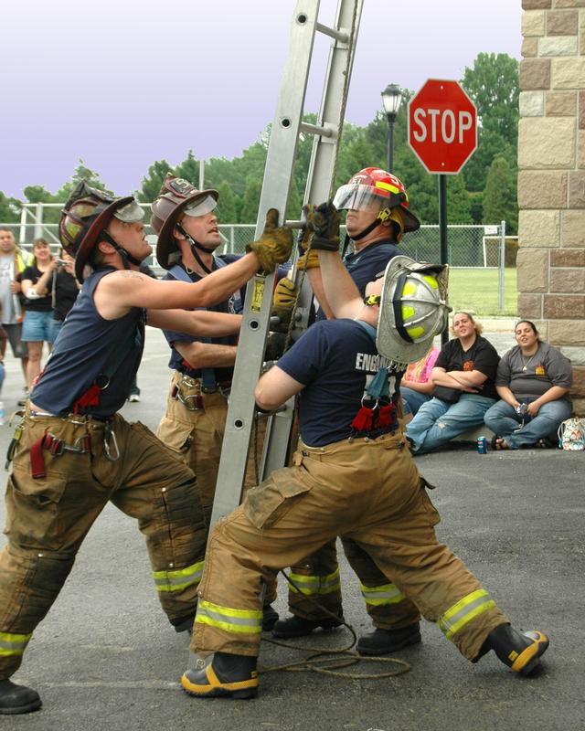 Captain Steve Pelna, Lt.'s Keith Green and Dale McClure, and FF Kevin Beans raising a ladder during a firefighter's competition.