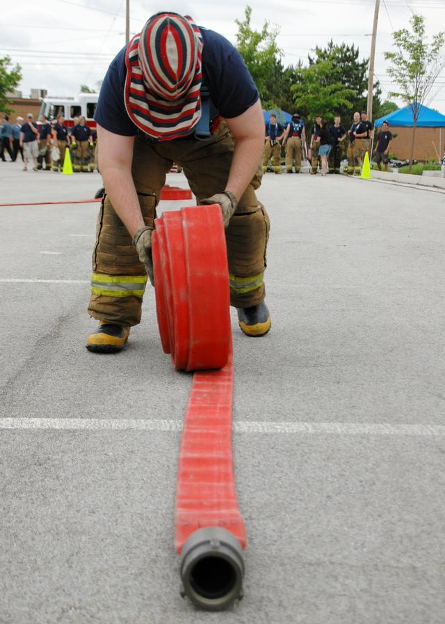 Captain Steve Pelna rolling hose during a firefighter's competition.